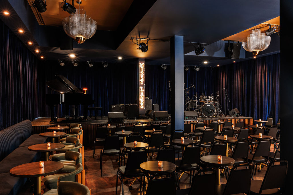 Dinner seating and stage at Missy Lane's Assembly Room designed by McNeill Brown